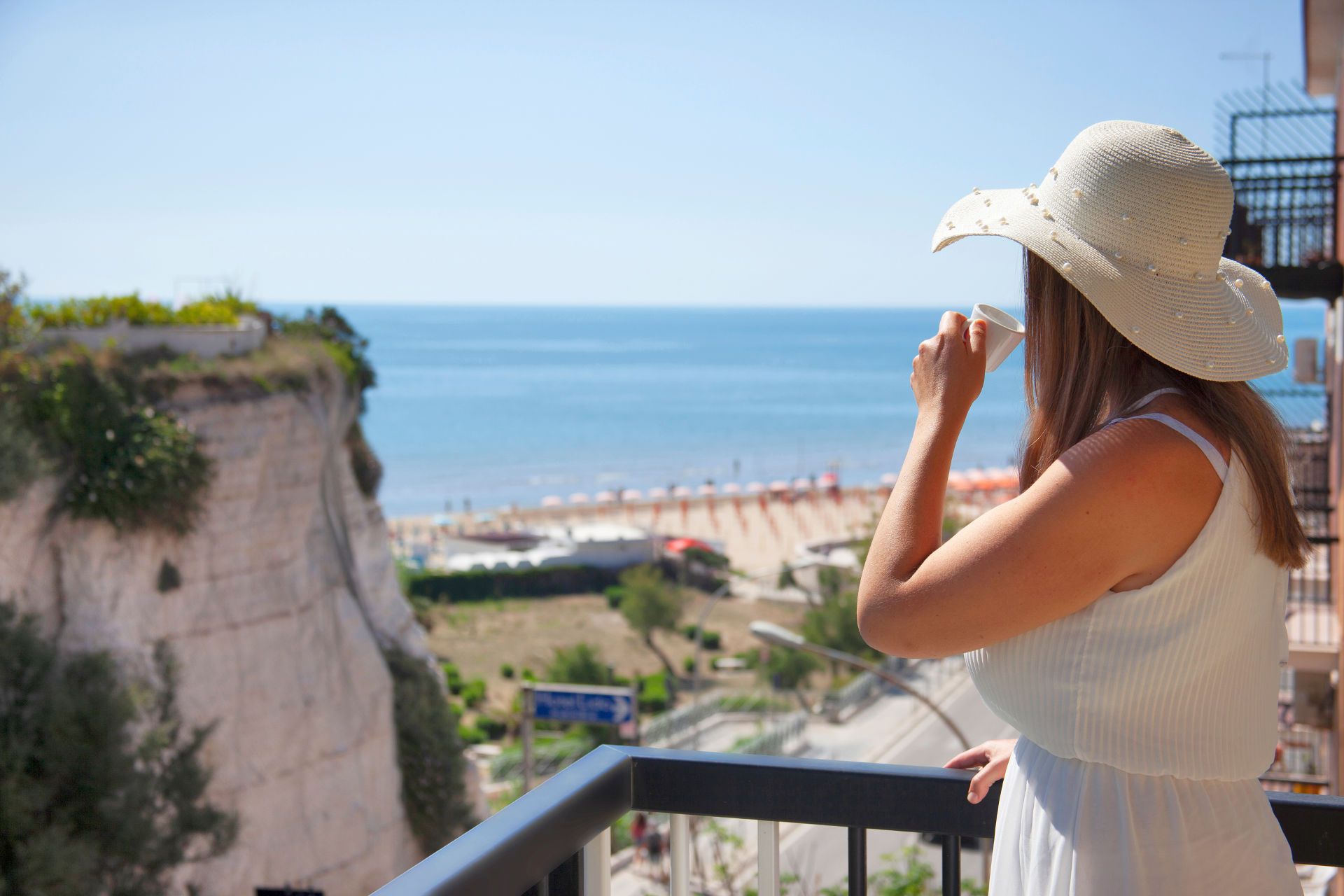 ragazza beve caffè  sul balcone del B&B Incanto di Luna a Vieste vicino al mare Pizzomunno