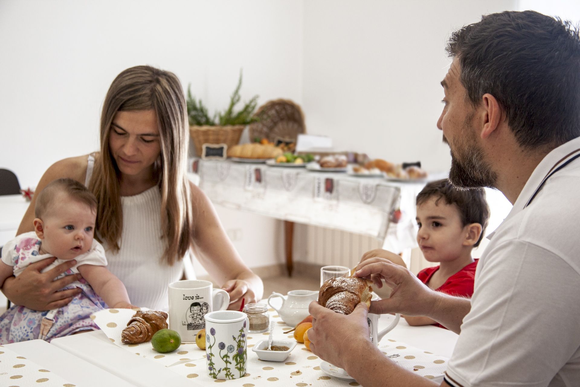famiglia a tavola durante la colazione con cornetti e cappuccino del B&B Incanto di Luna vicino al mare Pizzomunno Vieste nel Gargano